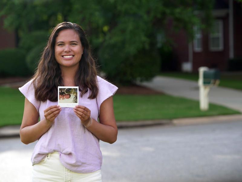 Woman holding up her baby picture