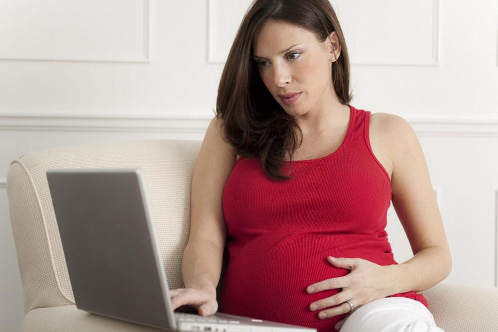 Pregnant mom in front of computer